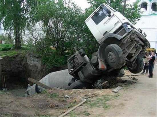 滿載水泥攪拌車不小心掉進(jìn)巨坑里，最后還得司機(jī)還得掏錢維修！